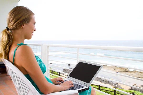 Young woman using laptop on balcony