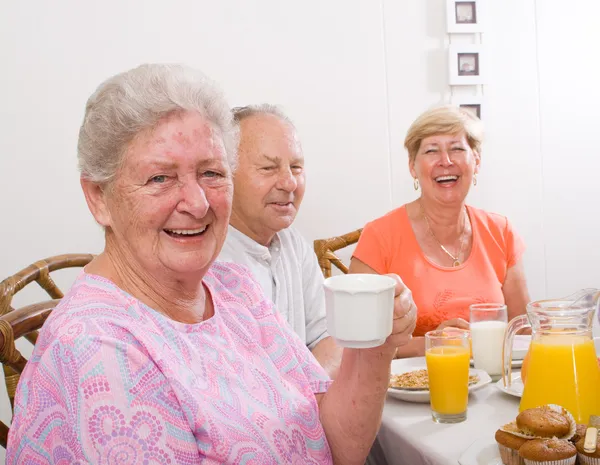 Happy senior friends having breakfast