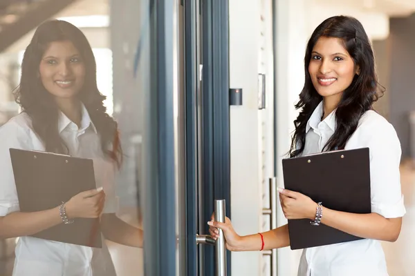 Indian white collar worker opening office door