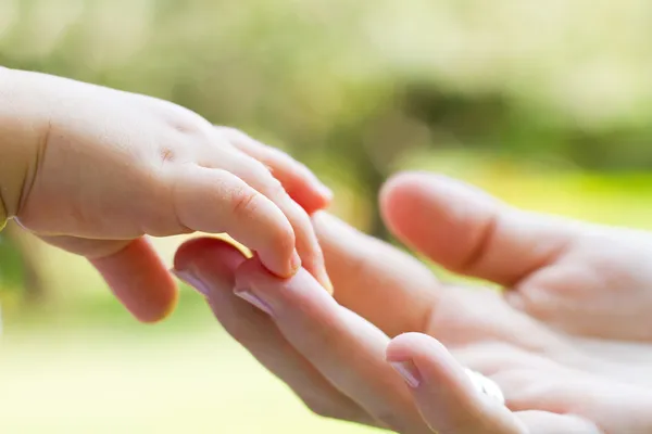 Caring mother and baby's hands