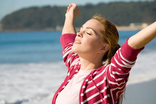 Spiritual woman with arms open wide on beach