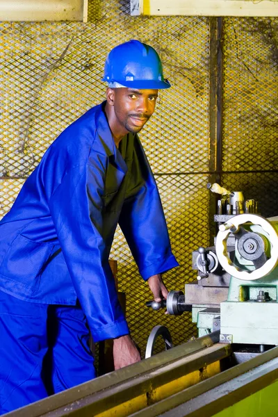 African lathe machine operator in workshop