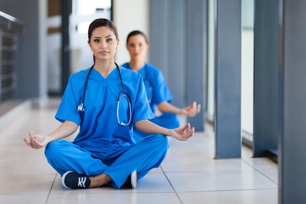 Two young healthcare workers meditation during break to release work pressure