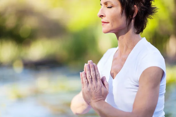 Middle age woman doing yoga meditation