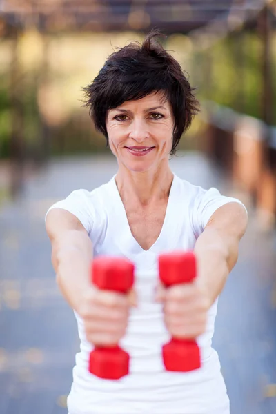 Active middle aged woman exercise with dumbbells