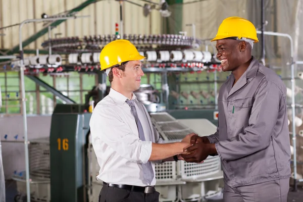 Factory manager handshaking with african american worker