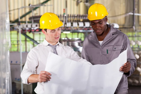 Factory manager and worker looking at production plan