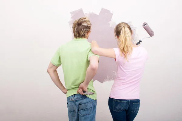 Young couple painting their new home