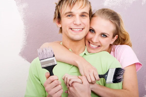 Happy young couple painting new home