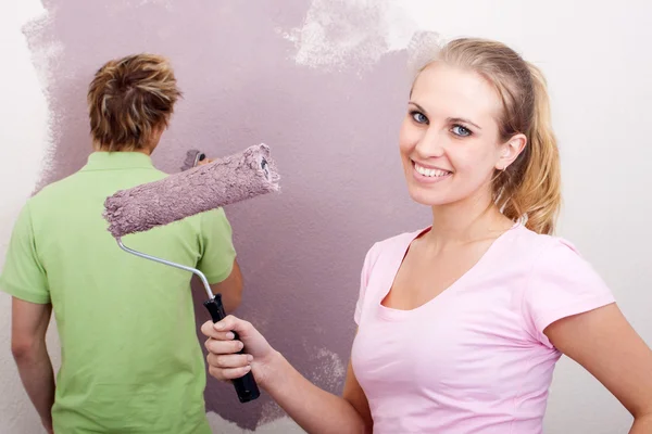 Happy young couple painting home together