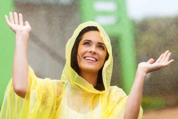 Happy young woman playing in the rain