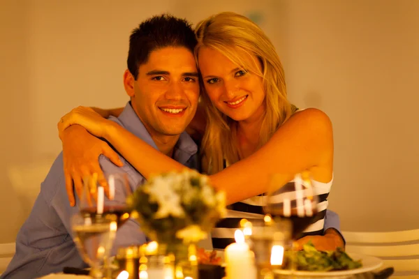 Loving young couple hugging in restaurant during dinner time