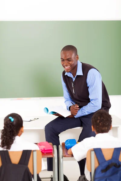 Male african primary school teacher teaching in classroom