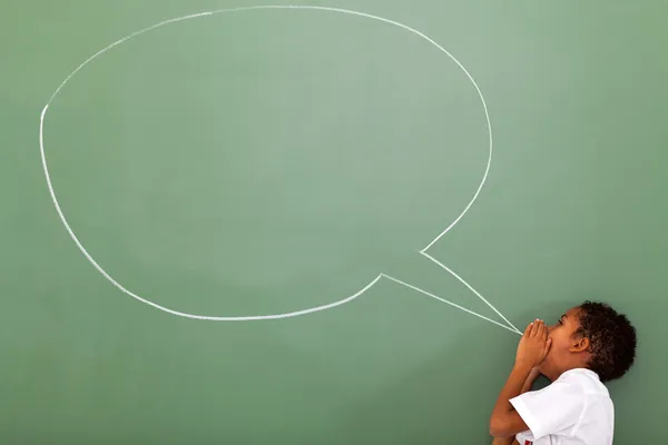 Elementary schoolboy shouting at chat box drawn on chalkboard