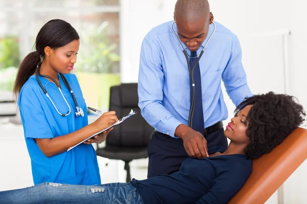 African american doctor examining female patient