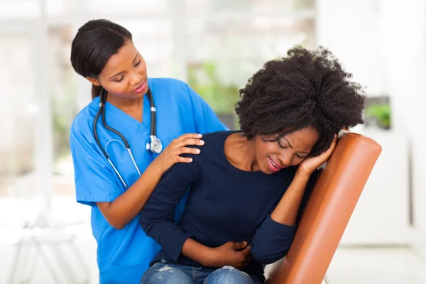 African female medical worker comforting a sick patient