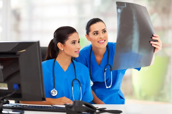 Two medical workers studying patient\'s x ray