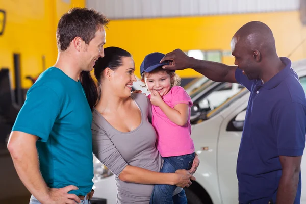 Friendly auto mechanic playing with little girl