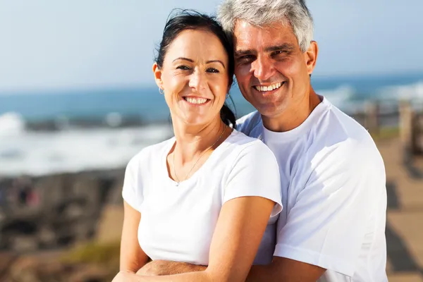 Middle aged couple hugging at the beach