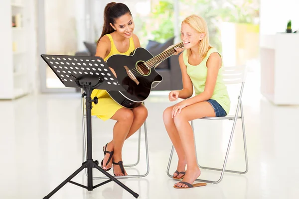 Young preteen girl having guitar lesson