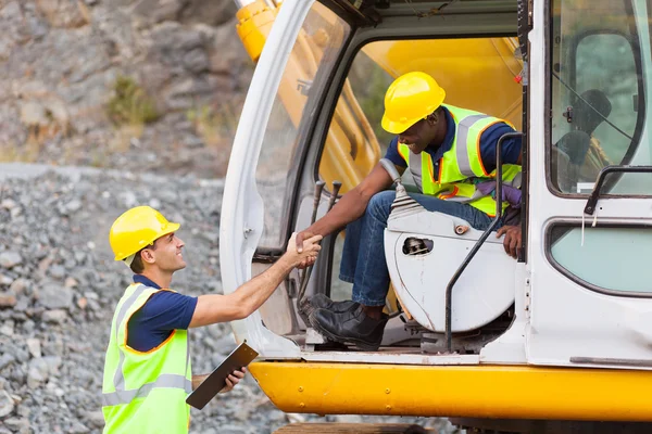 Construction manager handshaking with bulldozer operator