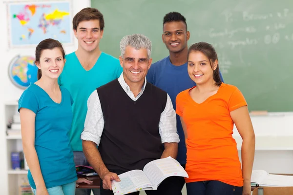 High school students in classroom with senior teacher