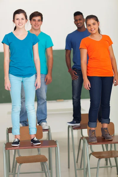 Group of high school students standing on desks