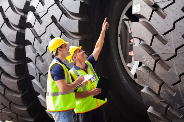 Shipping company workers checking industrial tires