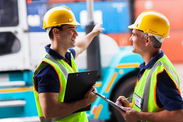 Young harbor workers pointing the forklift