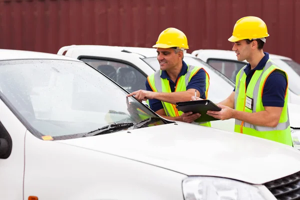 Shipping company worker inspecting cars