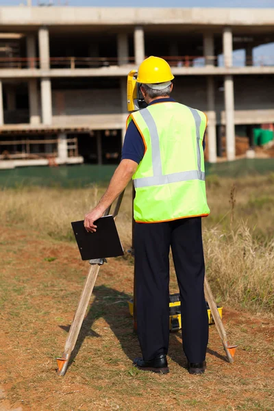 Rear view of land surveyor working at construction site