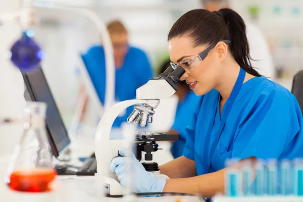 Young scientist using microscope