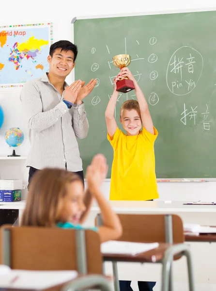 Male teacher applauding for student