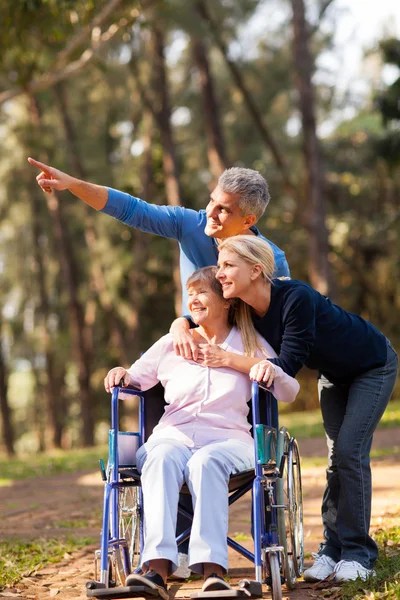 Loving mid age couple taking senior mother for a walk