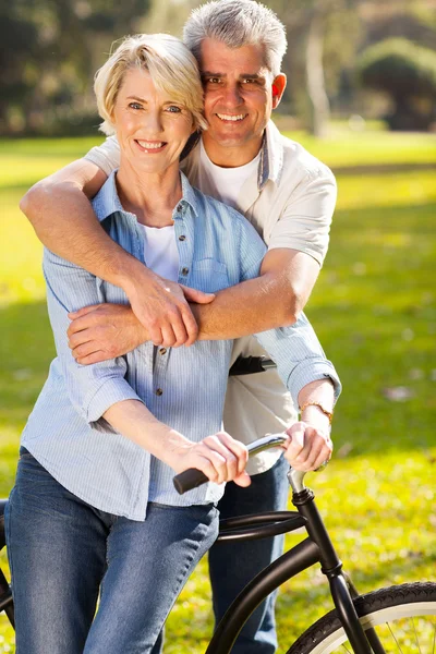 Middle aged couple on bike outdoors