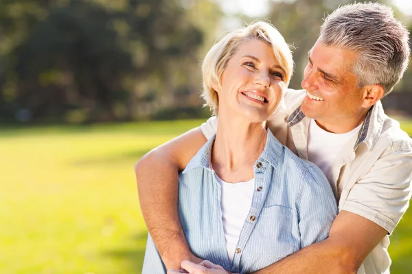 Middle aged couple embracing outdoors