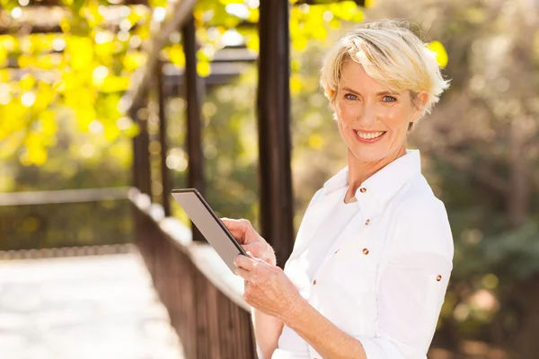 Middle aged woman holding tablet computer