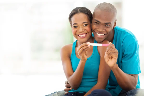 African couple showing positive pregnancy test
