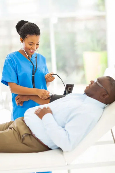 Doctor checking senior patient\'s blood pressure
