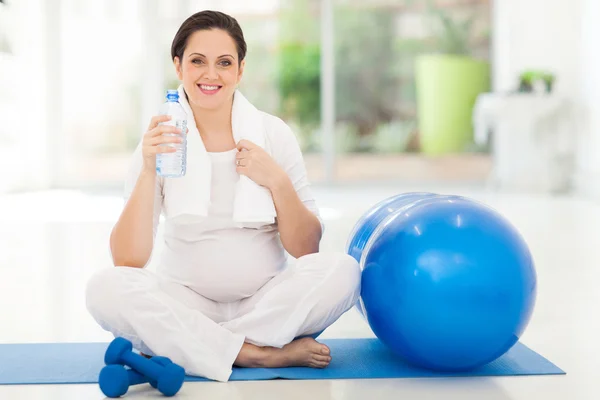 Pregnant woman holding bottle of water