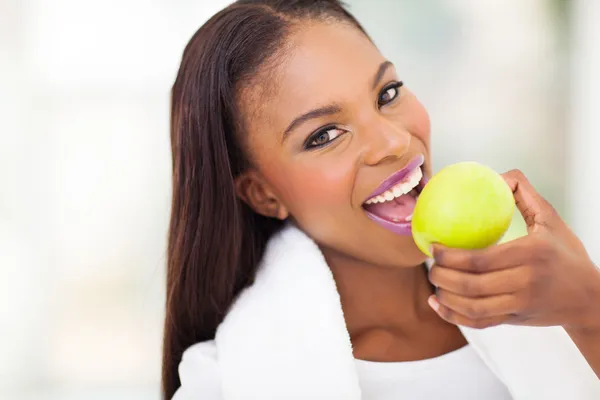 African woman eating apple