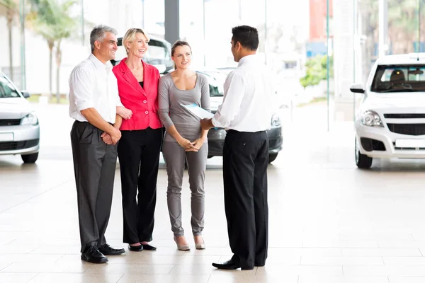 Vehicle salesman explaining contract to family