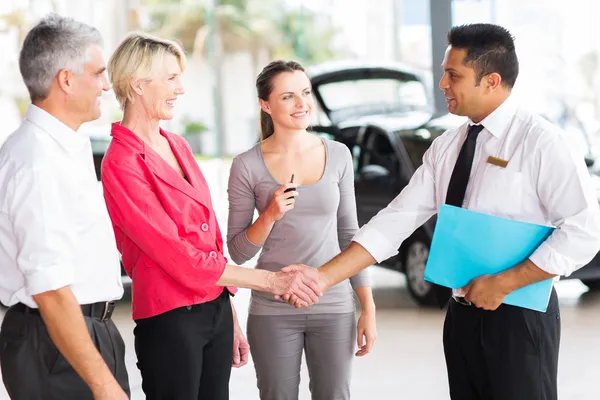 Woman handshaking with consultant after buying a car