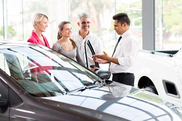 Salesman showing car to family