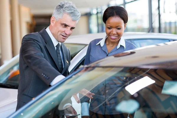 Dealer showing car to african customer