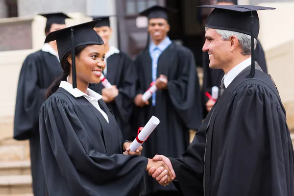 Afro american graduate handshaking with dean