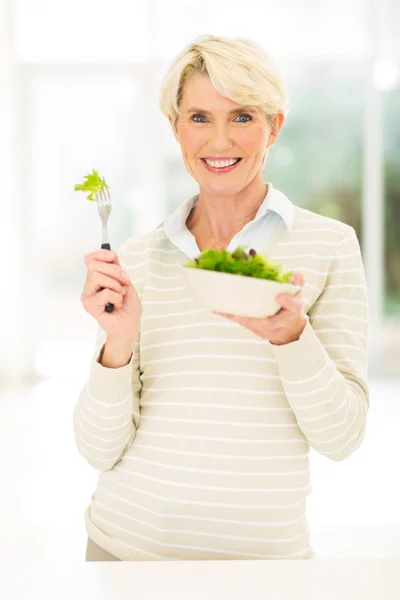 Mid age woman eating salad