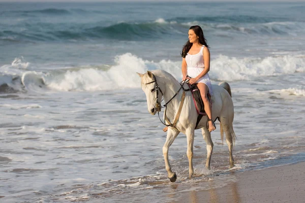Lady riding horse on beach