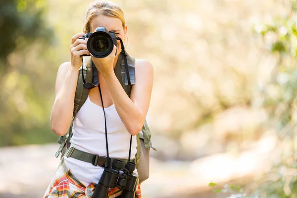 Young hiker taking photos in mountain