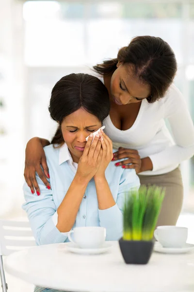 African woman comforting crying mother